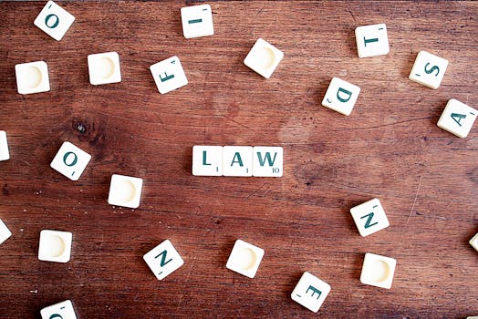 Scrabble tiles spelling 'LAW' on a wooden table, symbolizing connections to education and legality.